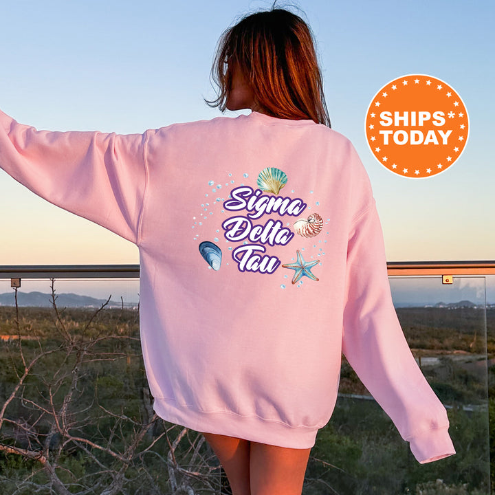 a woman in a pink sweatshirt is walking through a field
