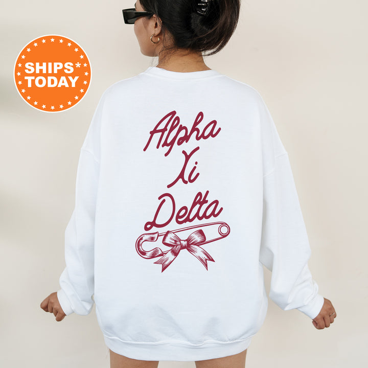 a woman wearing a white sweatshirt with a red ribbon on it