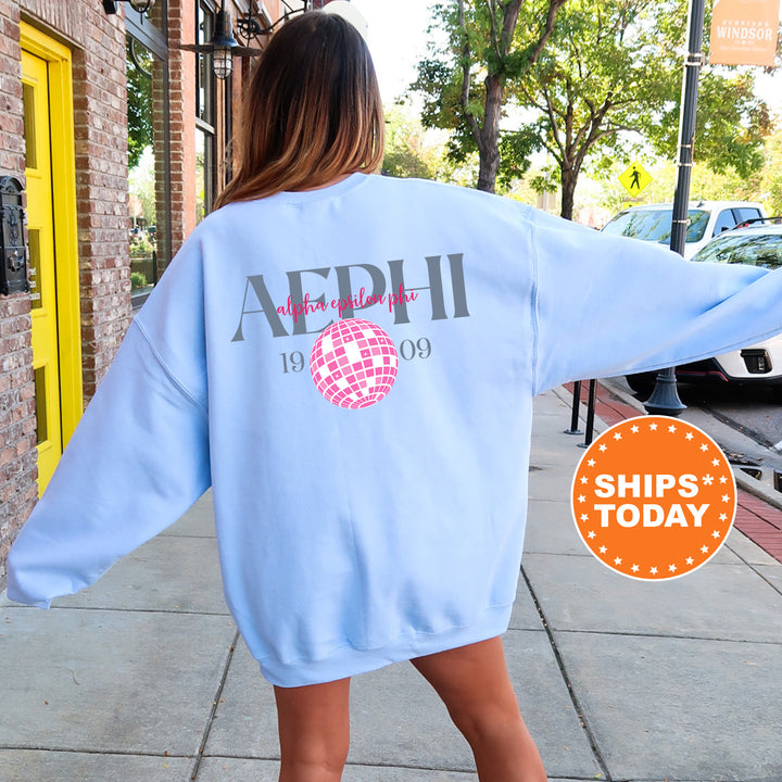 a woman walking down a sidewalk wearing a blue sweatshirt