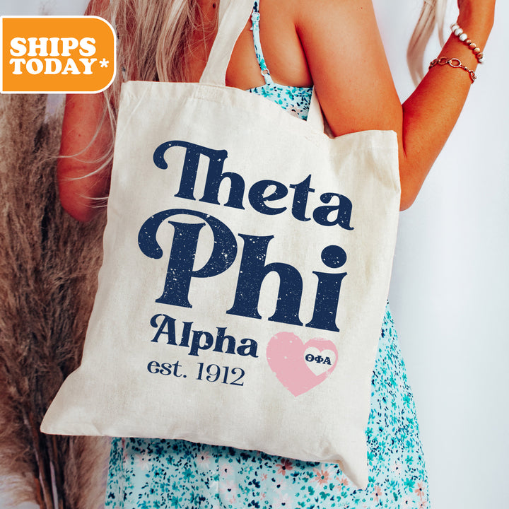 a woman holding a tote bag that says, thea phih alpha