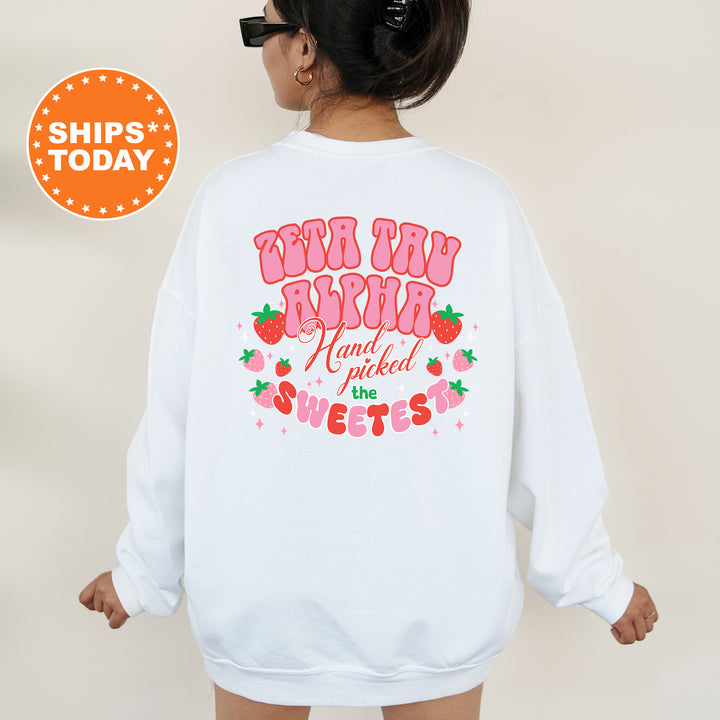 a woman wearing a white sweatshirt with strawberrys on it