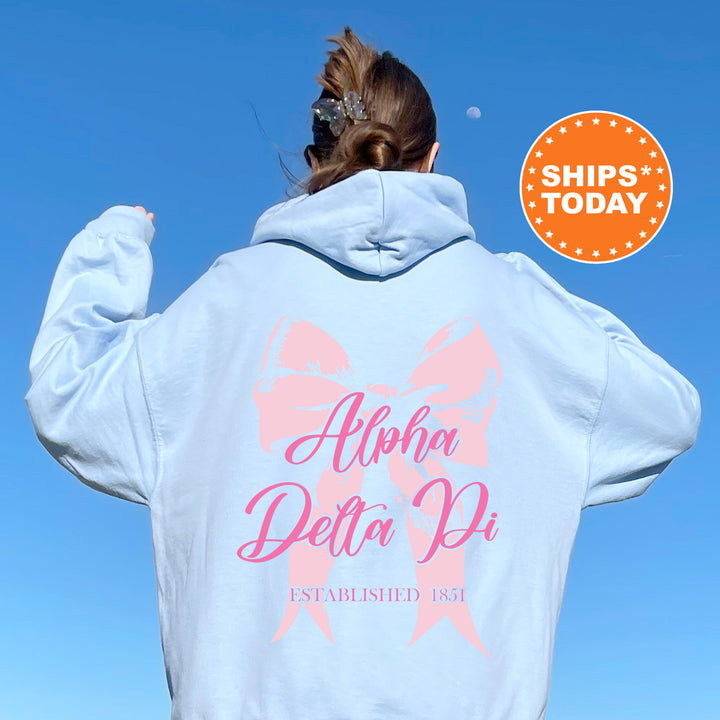 a woman wearing a white hoodie with a pink ribbon on it