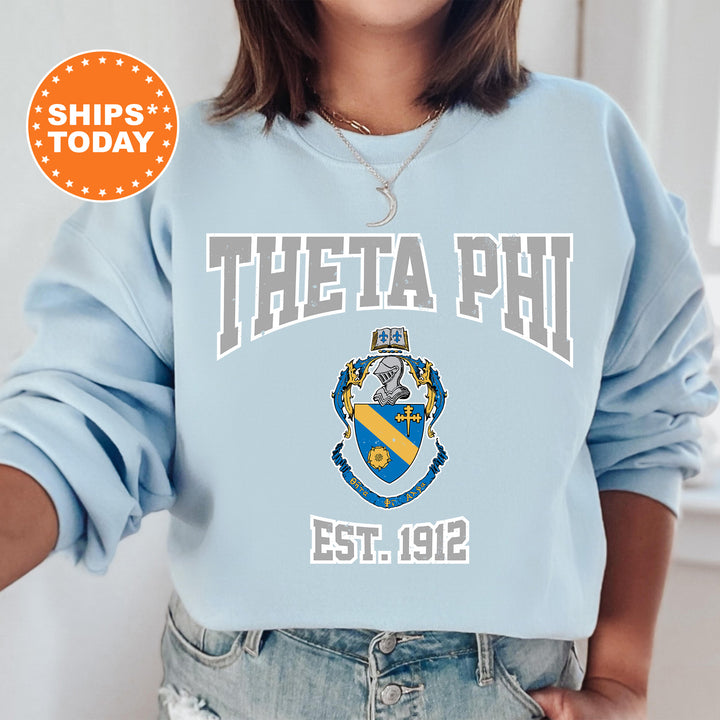 a woman wearing a blue sweatshirt with a phi phi crest on it