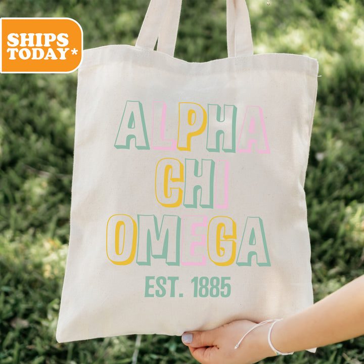 a person holding a bag with the words alpha chi omega on it