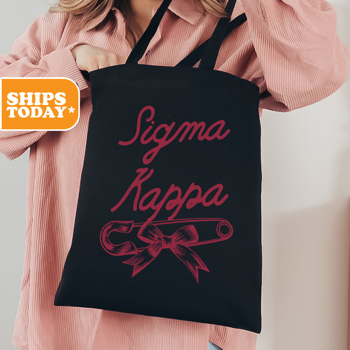 a woman holding a black shopping bag with pink lettering