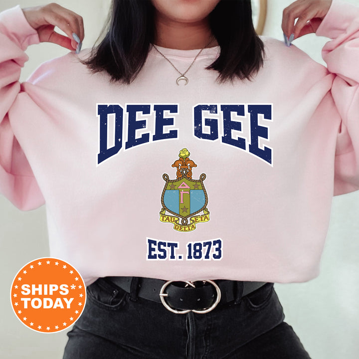 a woman wearing a pink sweatshirt with a crest on it