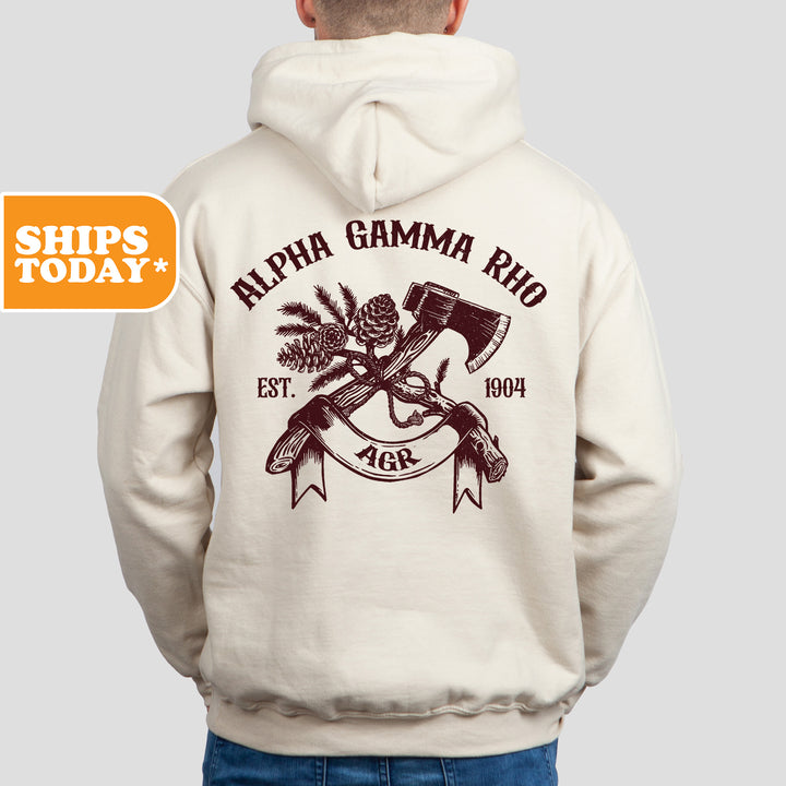 a man wearing a white hoodie with an image of a hammer and a pine