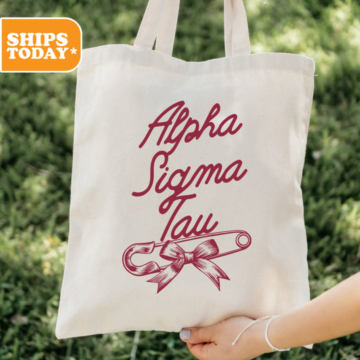 a person holding a tote bag with a ribbon on it