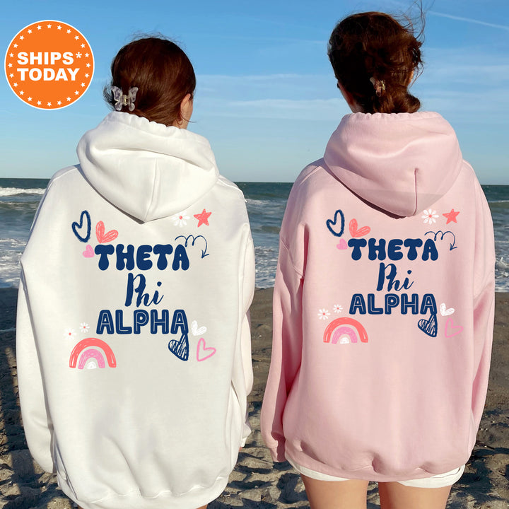 two girls wearing matching sweatshirts on the beach