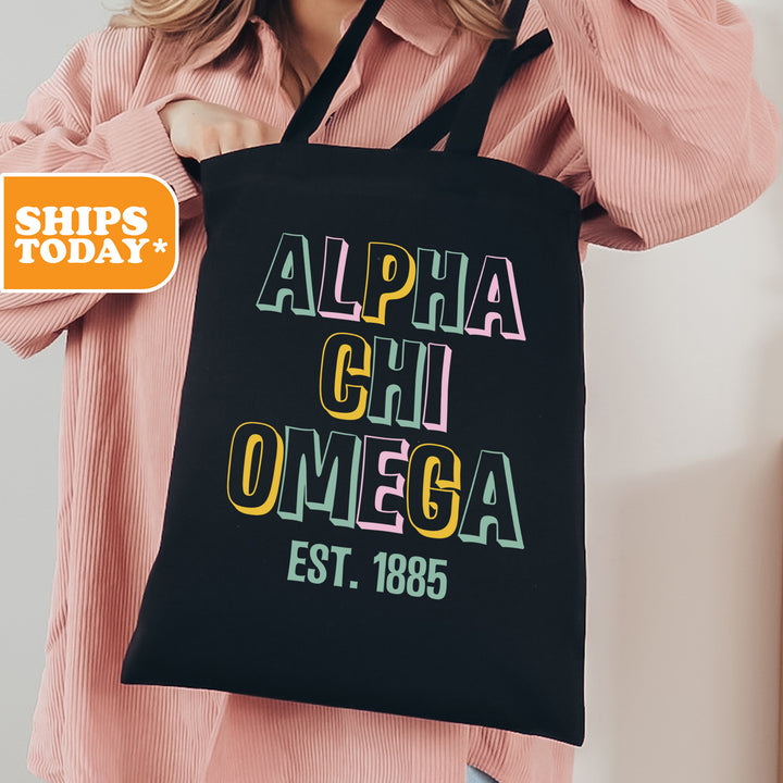 a woman holding a black tote bag with the words, alpha chi omega est