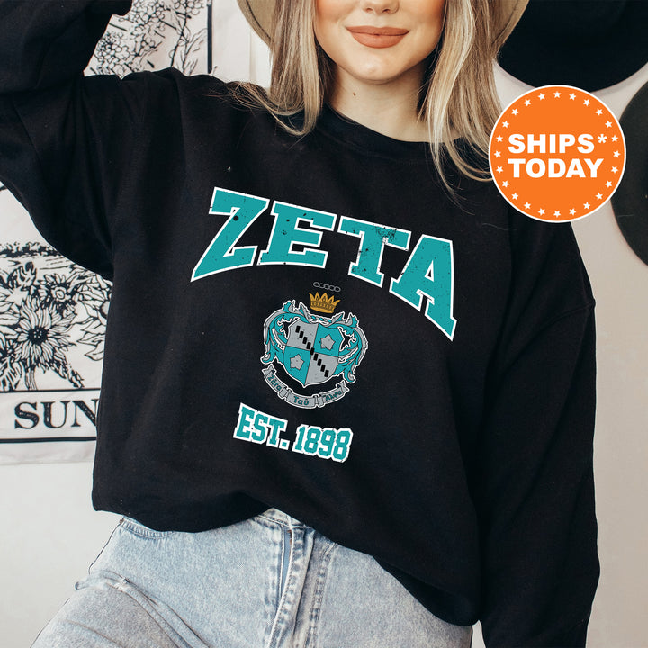 a woman wearing a black sweatshirt with a zeita crest on it