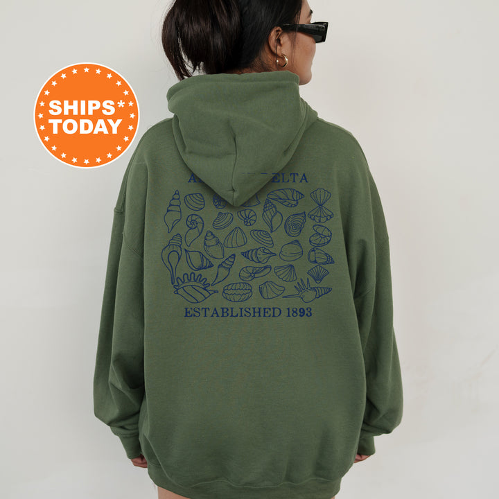 a woman wearing a green sweatshirt with a blue graphic on it
