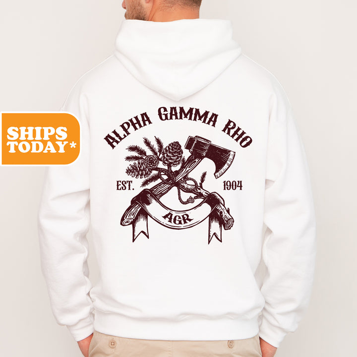 a man wearing a white hoodie with an image of a hammer and a pine