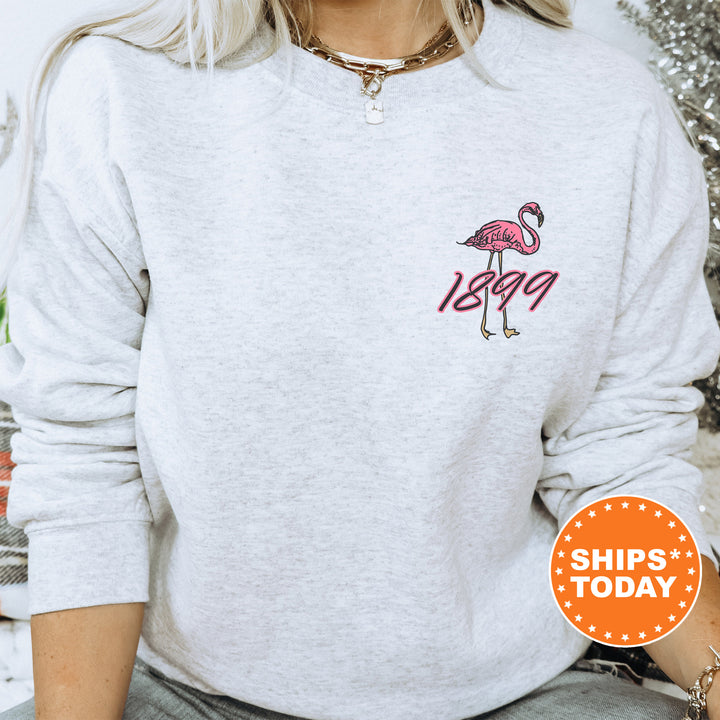 a woman wearing a white sweatshirt with a pink flamingo embroidered on it