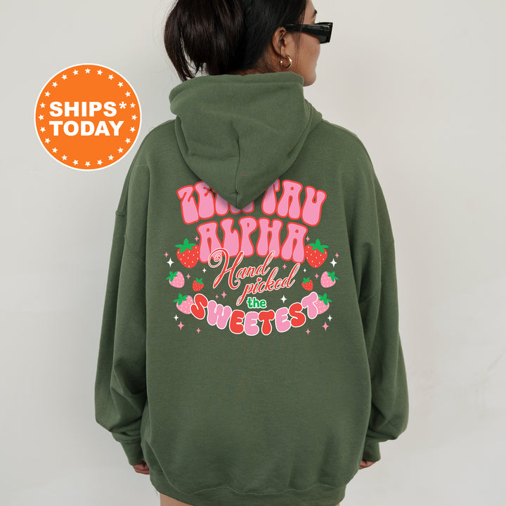 a woman wearing a green hoodie with a pink heart on it