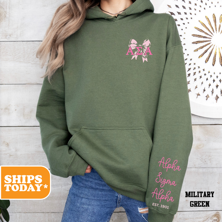 a woman wearing a green hoodie with a pink ribbon on it