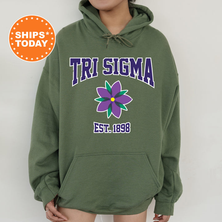 a woman wearing a green sweatshirt with a flower on it