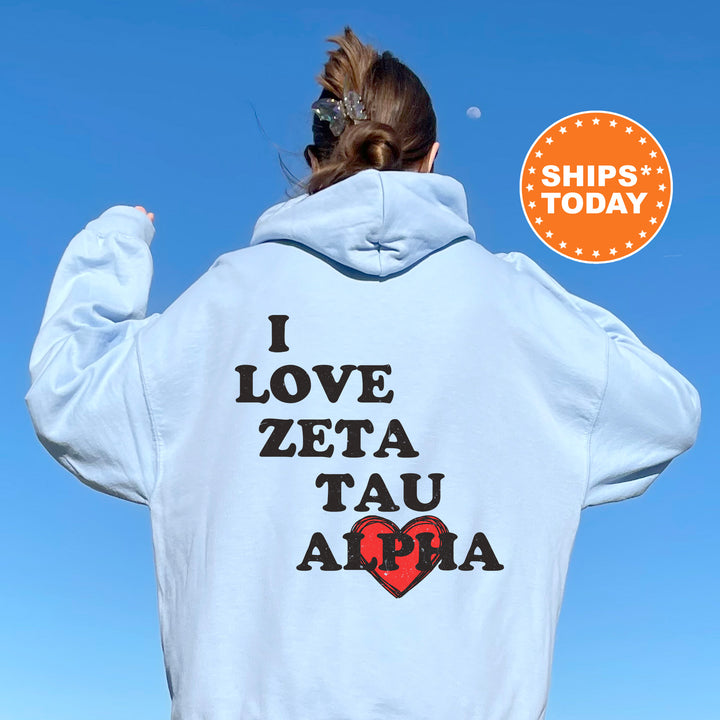 a woman wearing a white hoodie that says i love zeta tau apa