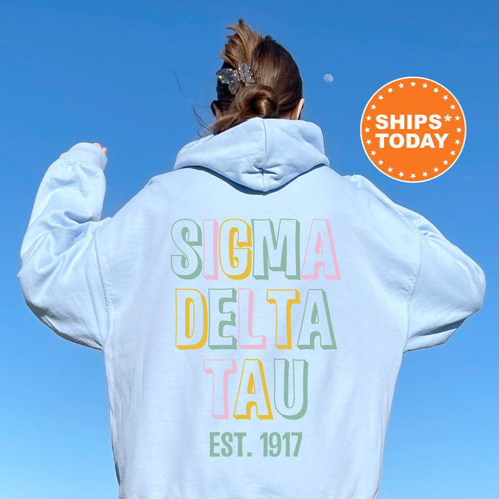 a woman wearing a white hoodie with the words soma delta tau on it