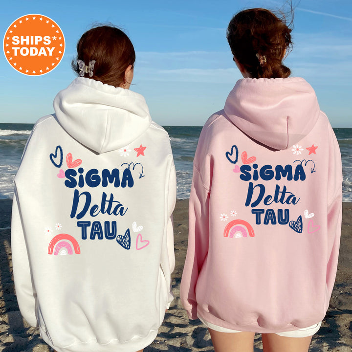 two girls wearing matching sweatshirts on the beach