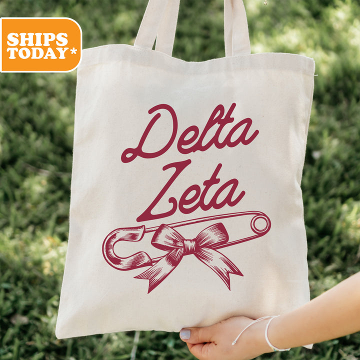 a person holding a tote bag that says delta zeia