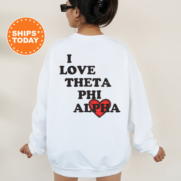 a woman wearing a sweatshirt that says i love thea phi ahra