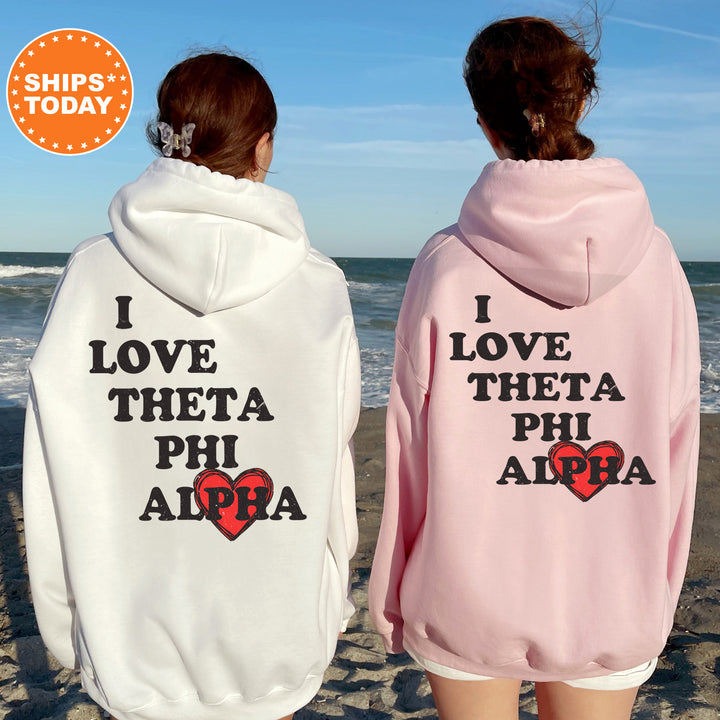 two women wearing matching sweatshirts on the beach