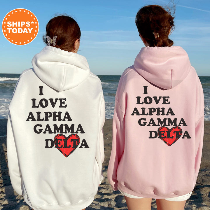 two women wearing pink and white hoodies on the beach