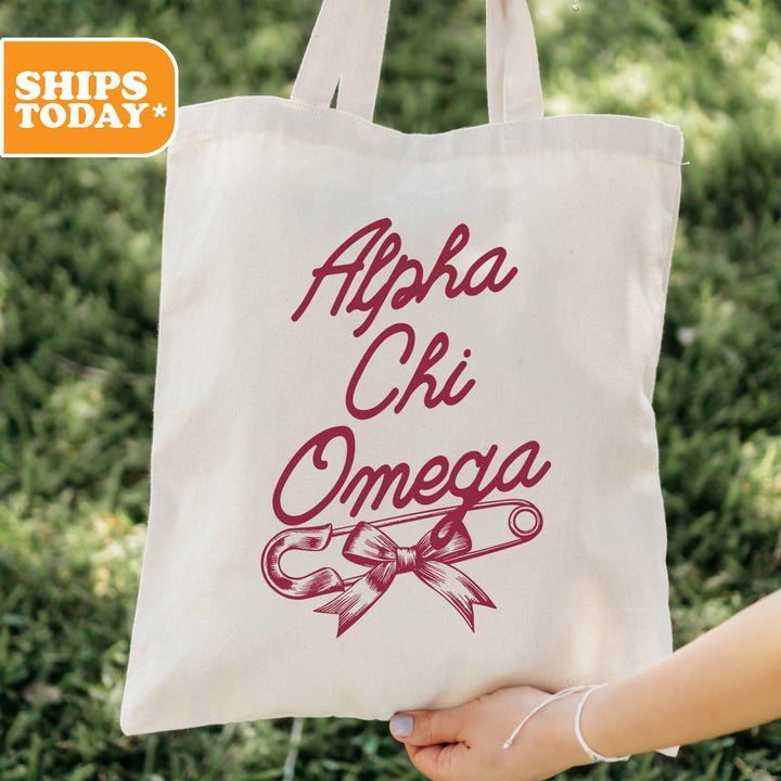 a person holding a white bag with the words ahha chi omega on it
