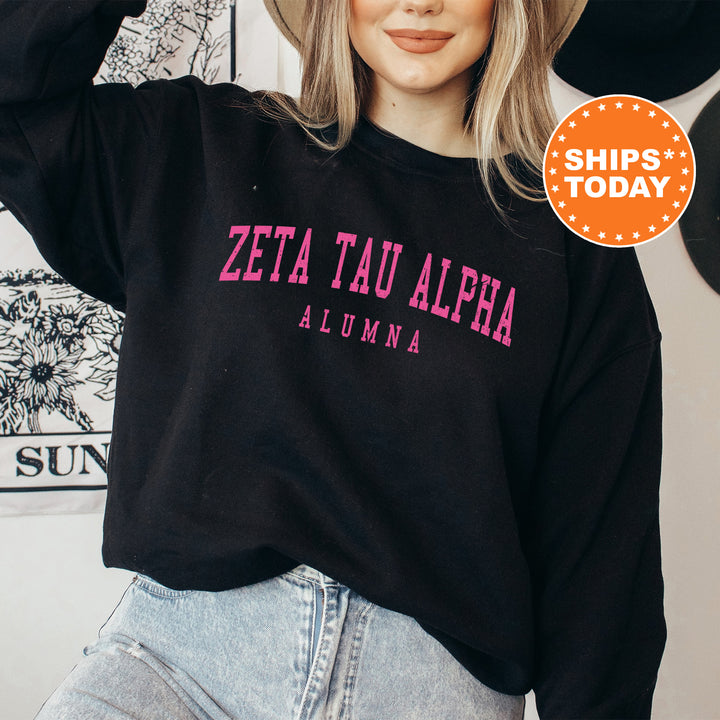 a woman wearing a black sweatshirt with pink letters