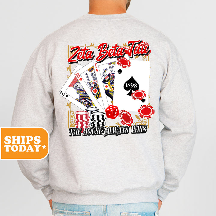 a man wearing a white sweatshirt with a picture of playing cards on it
