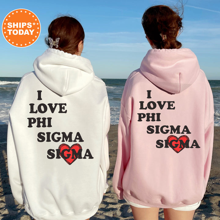 two women wearing pink and white sweatshirts on the beach