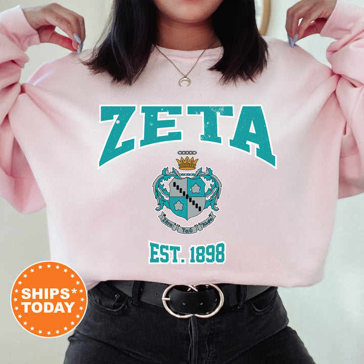 a woman wearing a pink sweater with a crest on it