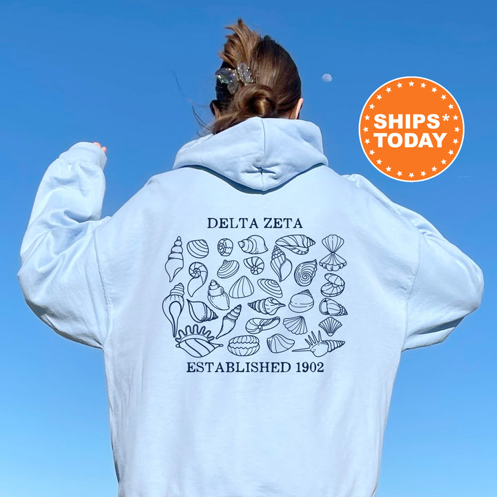 a woman wearing a white hoodie with the words delta eta established on it