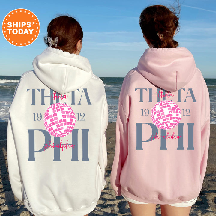 two women wearing matching sweatshirts on the beach