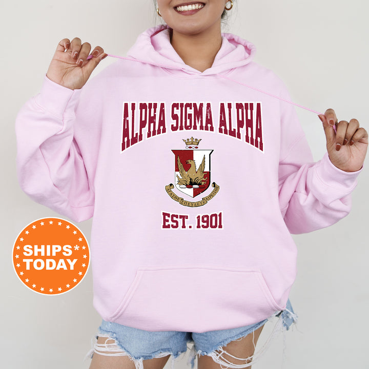 a woman wearing a pink hoodie with the words alpena stigma alpha