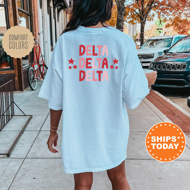 a woman is walking down the sidewalk wearing a t - shirt that says delta delta