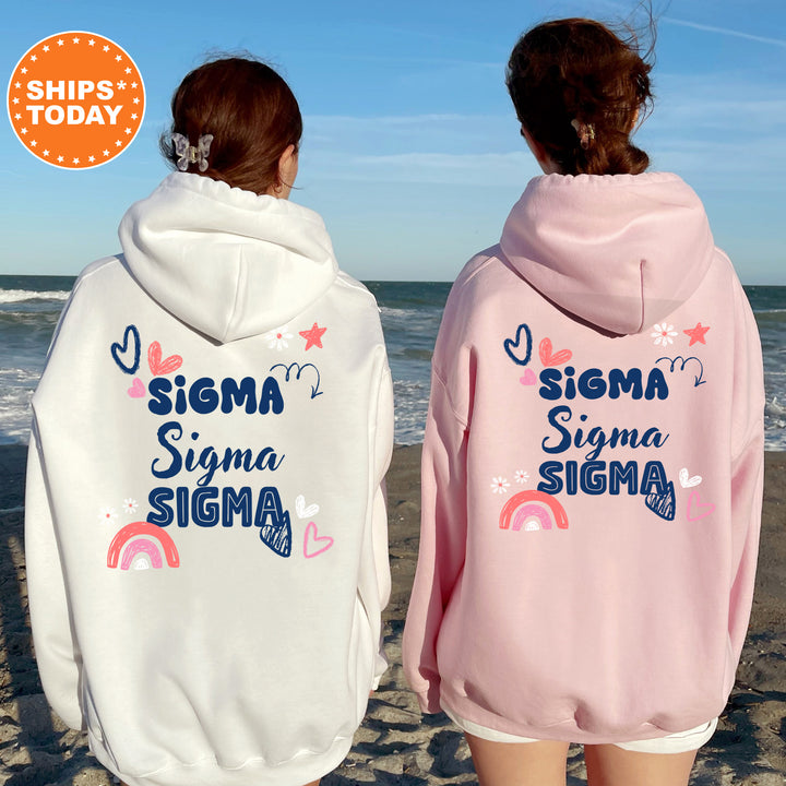 two girls wearing matching sweatshirts on the beach