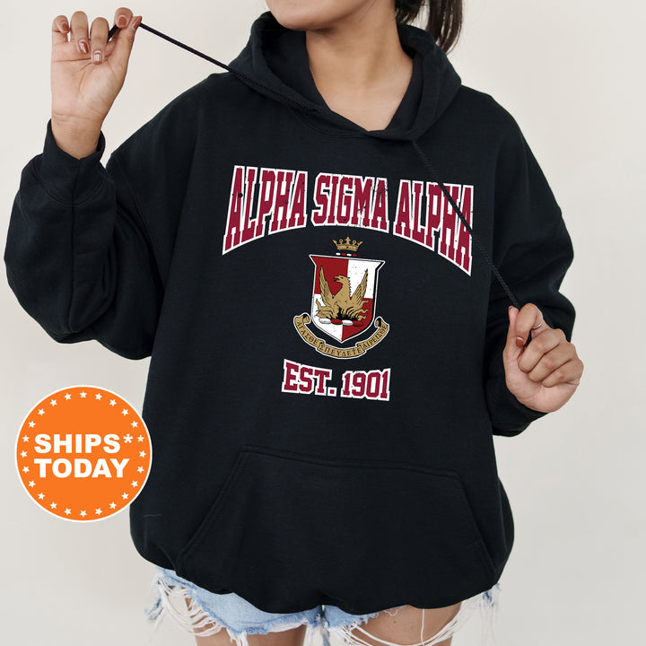 a woman wearing a black hoodie with a crest on it