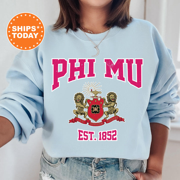 a woman wearing a sweatshirt with the phi mu crest on it