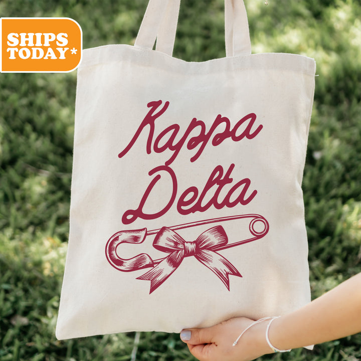 a person holding a tote bag with a ribbon on it