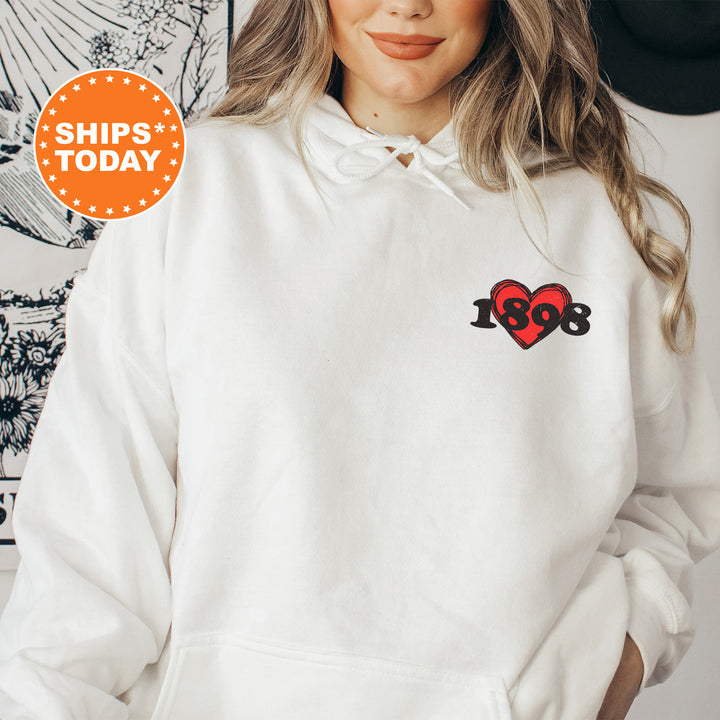 a woman wearing a white hoodie with a red heart on it