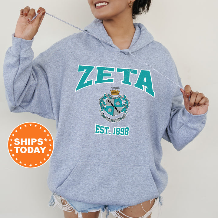 a woman wearing a zeta hoodie holding a toothbrush