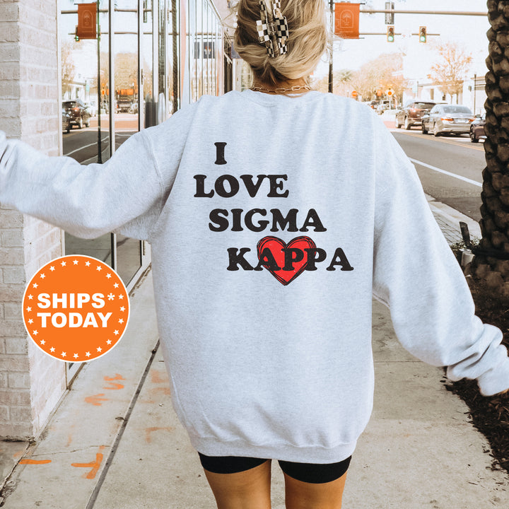 a woman walking down a sidewalk wearing a sweatshirt that says i love stigma kapa