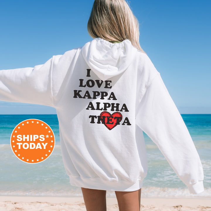 a woman standing on a beach wearing a white hoodie