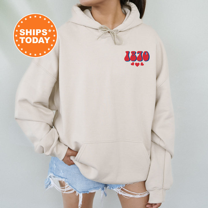 a woman wearing a white hoodie with a red, white, and blue design