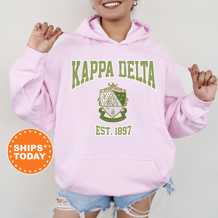 a woman wearing a pink kapa delta hoodie