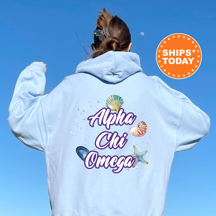 a woman wearing a white hoodie with the words alpaca chi omega on