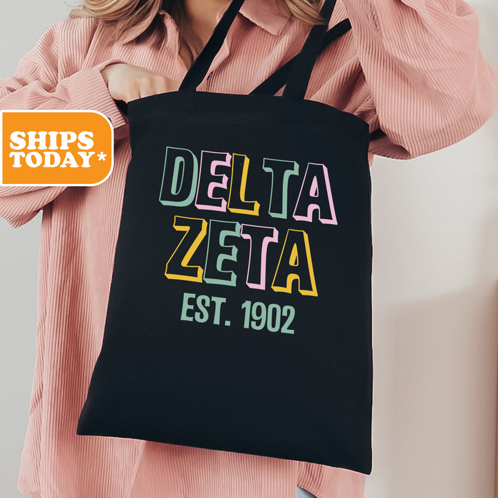 a woman holding a black delta delta tote bag