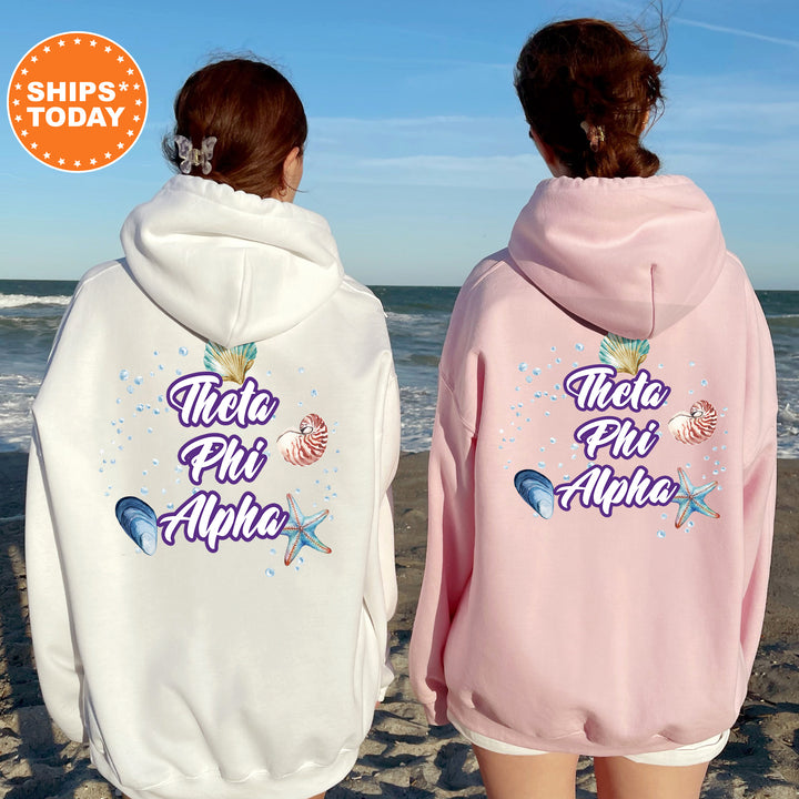 two women wearing matching sweatshirts on the beach